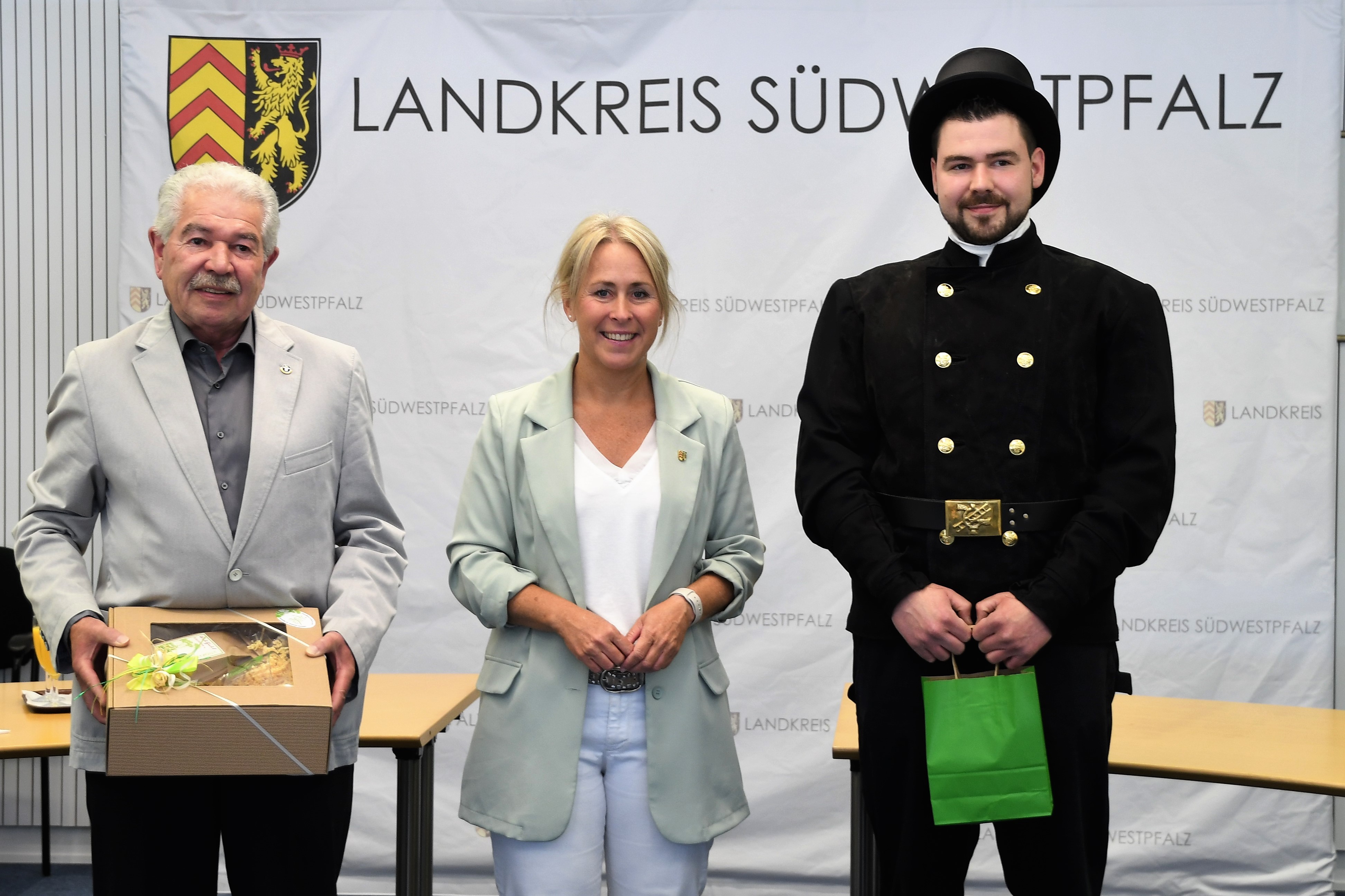Landrätin Dr. Ganster umrahmt von zwei Glücksbringern: dem ausgeschiedenen Schornsteinfeger Alexander Bold und dem für den Kehrbezirk XII seit dem 01.07. neu verpflichteten Daniel Bold.